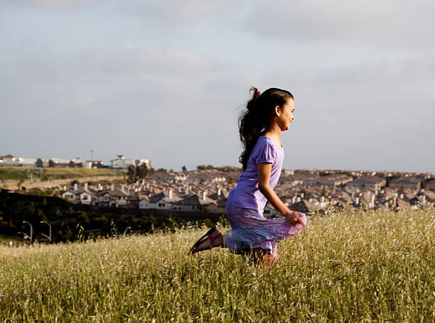 Young girl running through a field.  Some motion blur.