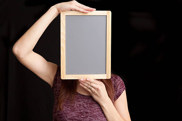 istock Womaqn Holding Blank Chalkboard Over Face 185263700