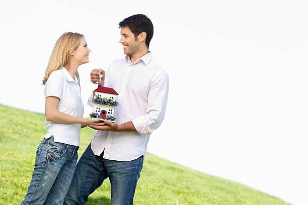 happy couple with house and key "happy couple posing with a house miniature and key for privately owned home concepts, selective focus, house miniature self made by memore of this and other families," hypothecary stock pictures, royalty-free photos & images