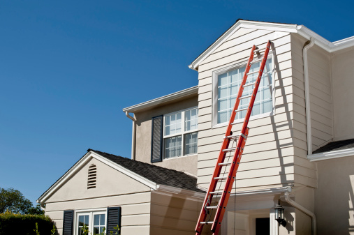 Cape Cod style house with ladder against siding.