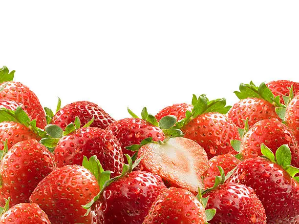 A pile of fresh ripe strawberries with dewdrops on white background.