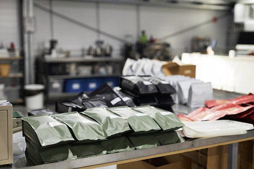 Close up background image of various coffee bean bags in packaging department of small coffee roastery, copy space