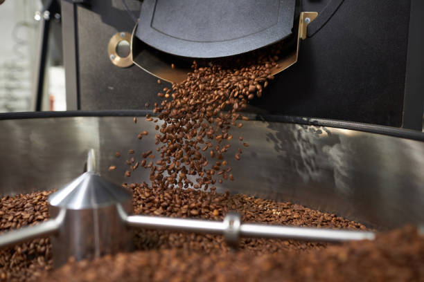istock Background of Fresh Coffee Beans Spilling From Industrial Coffee Roaster 1852647363