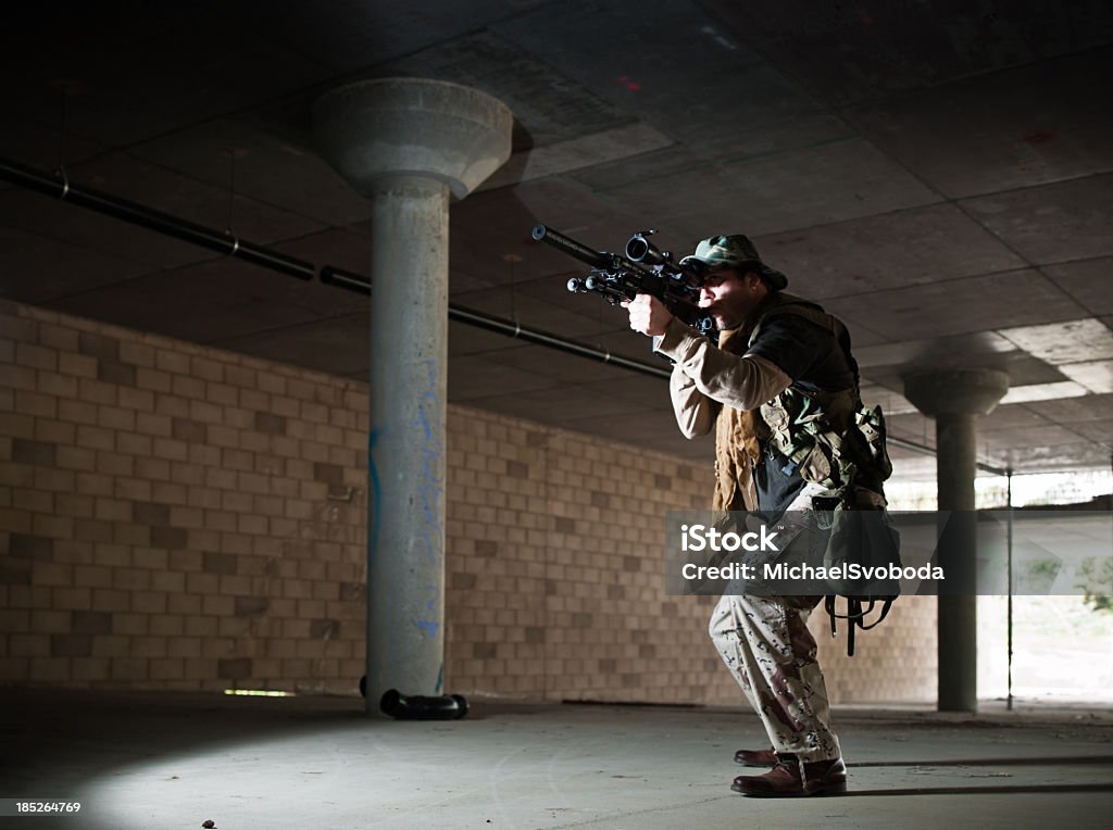 Urban Warfare An urban soldier aiming his gun in a contrete structure. Aiming Stock Photo