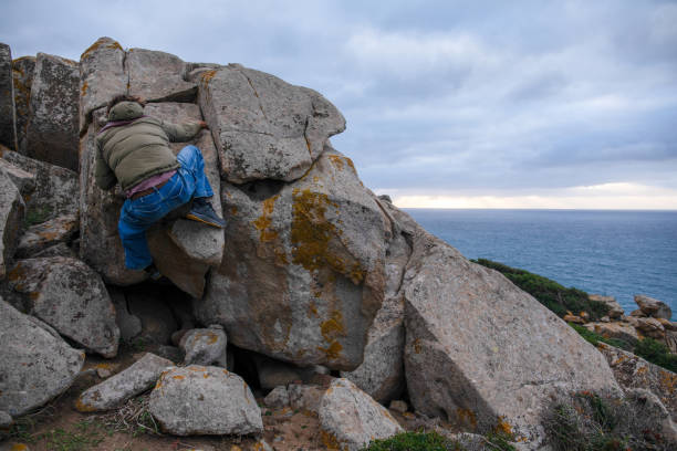 istock Young man scrambles up boulders 1852647922