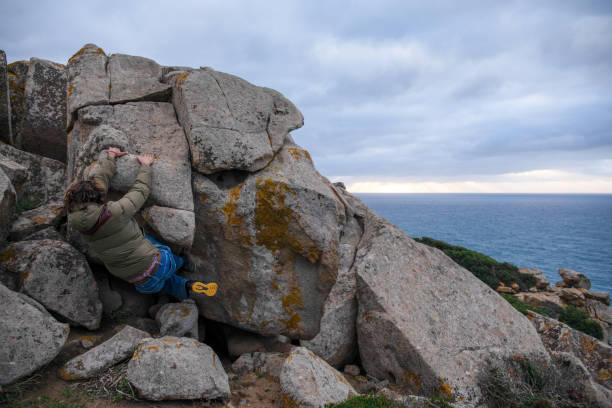 istock Young man scrambles up boulders 1852647923