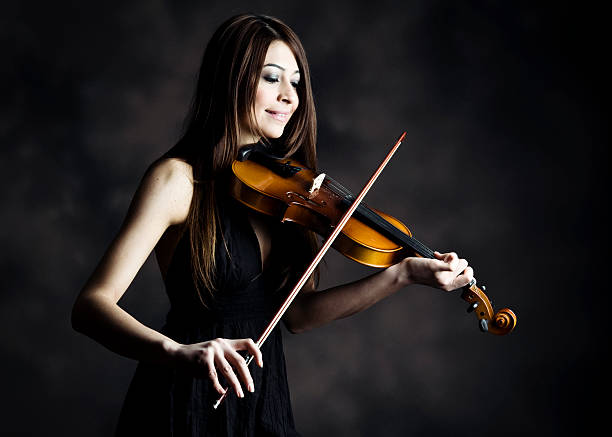 istock Young woman playing violin 185265009