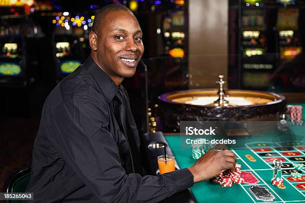 Hombre Jugando A La Ruleta En Un Casino Foto de stock y más banco de imágenes de Casino - Casino, Afrodescendiente, Jugar a juegos de azar
