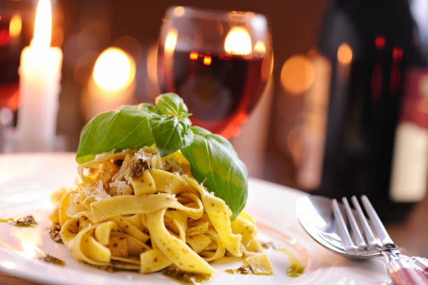 Homemade pappardelle with pesto and parmesan cheese Homemade pappardelle with pesto and parmesan cheese served with red wine evening meal stock pictures, royalty-free photos & images