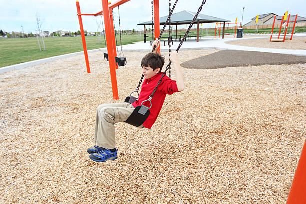 Community Park A lone elementary age boy having fun in a community park. mm1 stock pictures, royalty-free photos & images