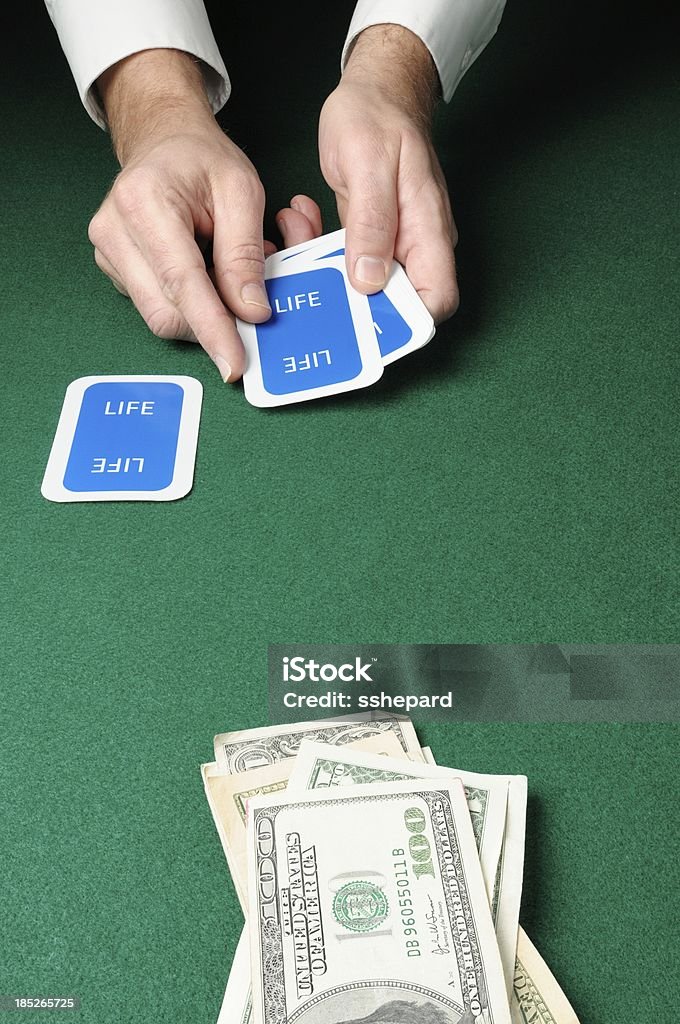 Life card game with money "Dealing the life cards with money in foreground, copy space.Cards made by contributor" Casino Worker Stock Photo