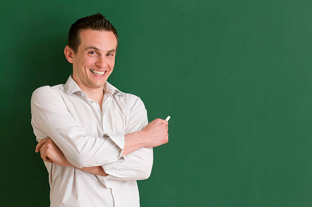istock smiling teacher holding a chalk 185265857