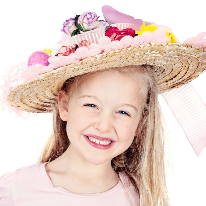 little girl in a hat walking in a field in summer