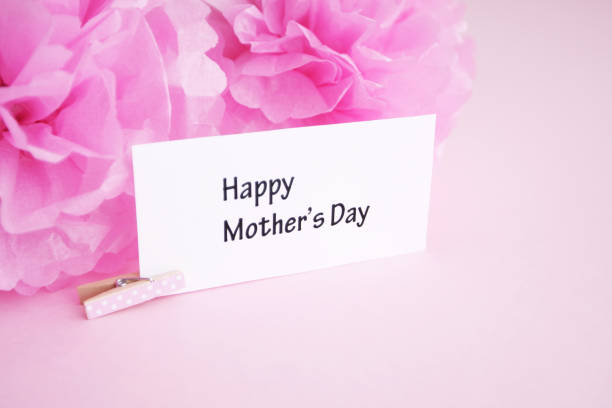 Happy mothers day gift tag with pink pom poms.