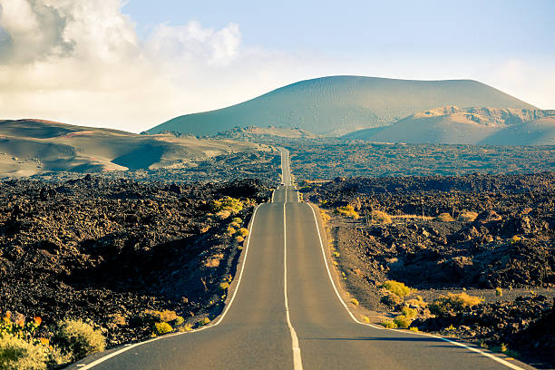 caminho no parque nacional de timanfaya, ilhas canárias - desert road fotos imagens e fotografias de stock