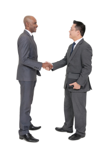 African and Chinese businessman shake hands and greet each other or close a deal. Isolated onwhite background.