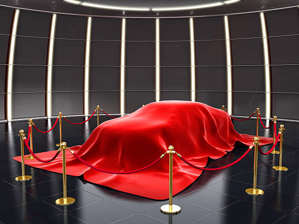 New car model exhibition New model covered with red velvet with stanchion ropes and pole barriers.Similar: car show stock pictures, royalty-free photos & images