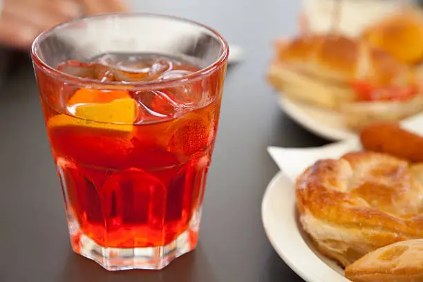 Glass of Spritz and salty flaky pastries.