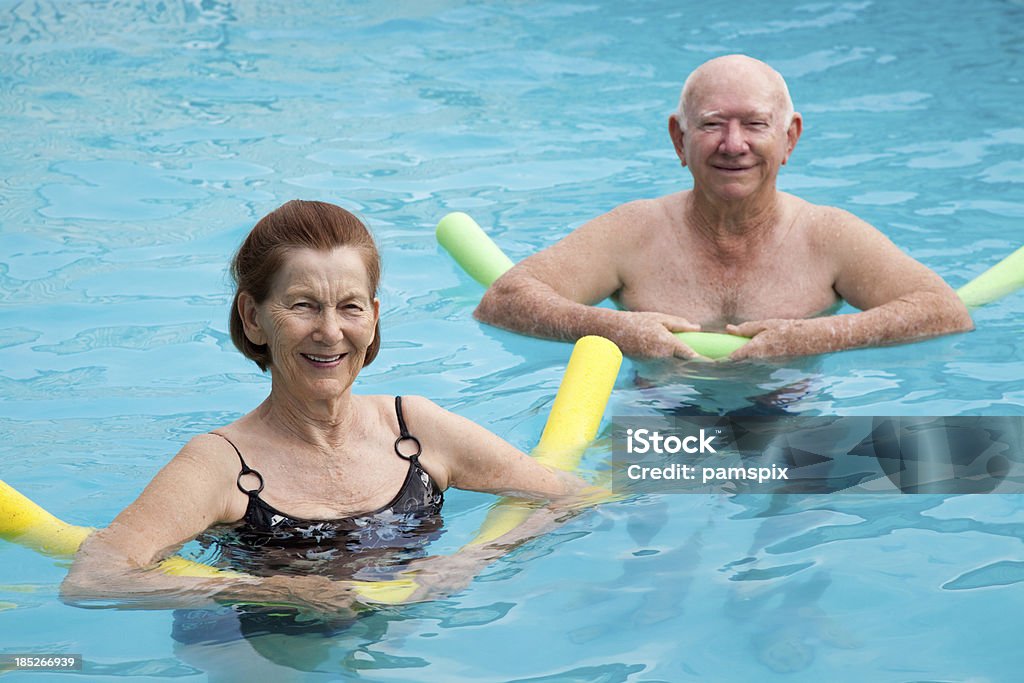 Homem Maduro e Mulher na piscina com boias - Foto de stock de Aeróbica Aquática royalty-free