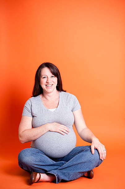 istock Young Pregnant Mother Isolated on Orange 185267197