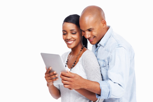 Young African-American couple admire their new tablet while isolated on white background