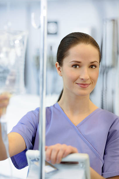 istock Young beautiful nurse checking IV bag 185267469