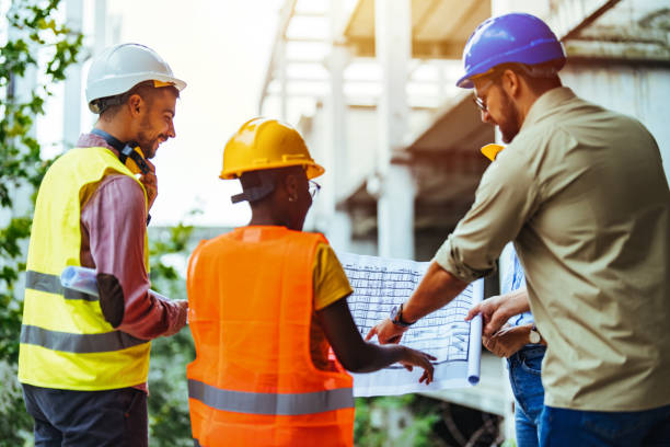 istock Construction workers standing on outdoor construction site and discuss the building plans. 1852675582
