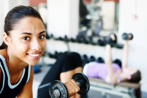istock Pretty girl doing biceps curls smiles 185267983