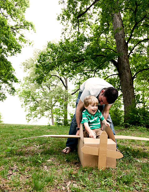 istock Man pushing a boy in a cardboard plane 185268095