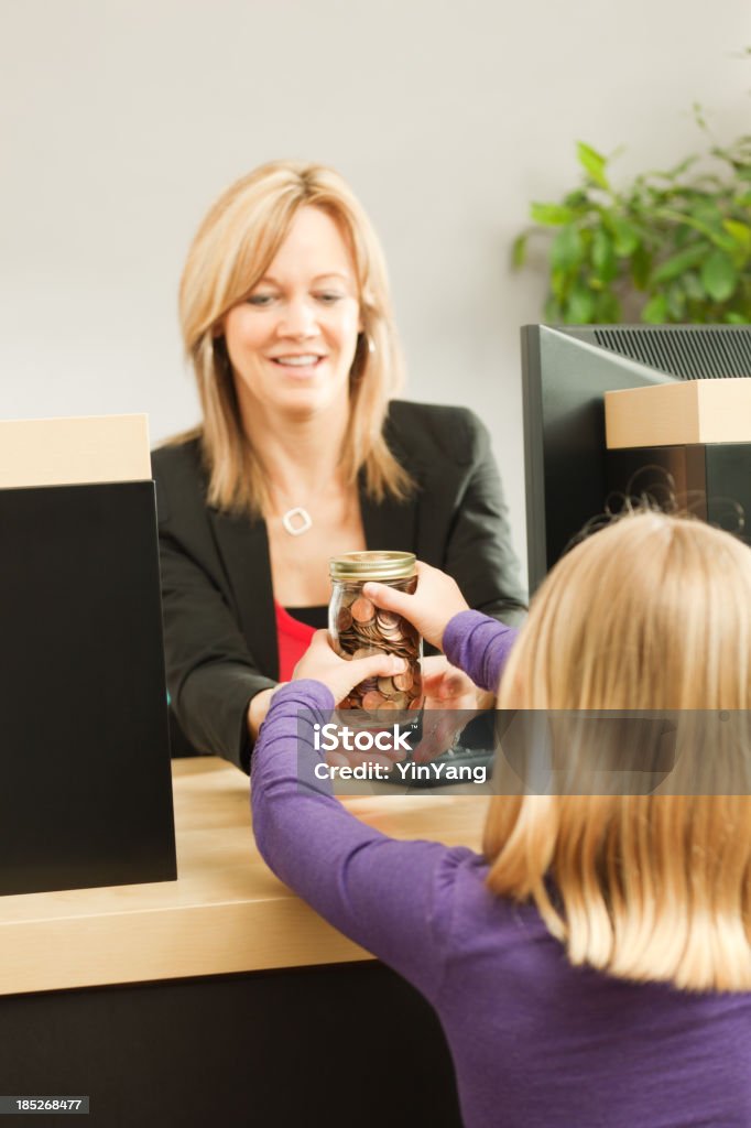 Giovane ragazza di apprendimento sul salvataggio di prelevare denaro al cassiere di banca - Foto stock royalty-free di Impiegato bancario