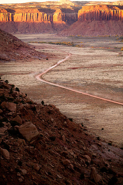 istock Car speeding down dusty desert road in Utah at sunset 185268550