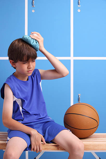 giovane feriti giocatore di basket - physical injury sport child locker room foto e immagini stock