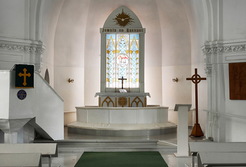 Background image of ethereal church interior in all white with stained glass window at altar