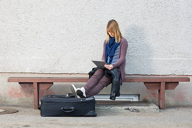 istock Young woman sitting on train station,working with digital tablet 185269795