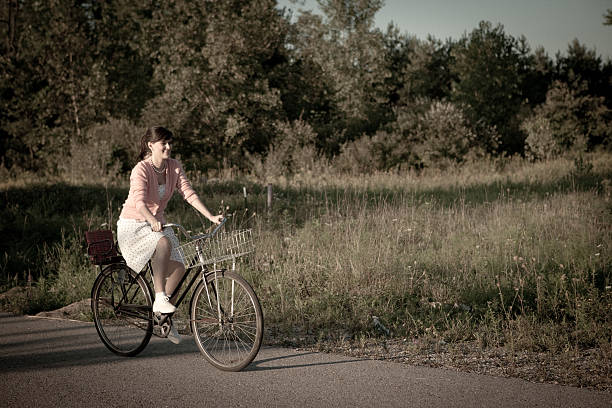 istock Retro Gal Riding Vintage Bicycle Down Country Road 185269876