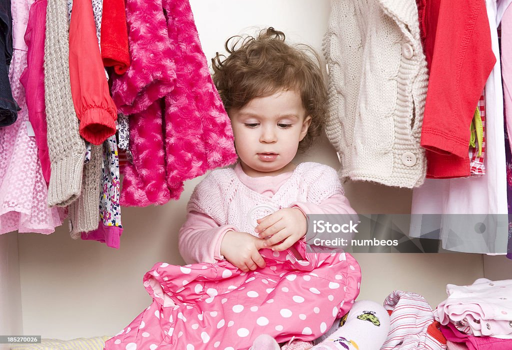 Baby girl choosing her clothes More baby clothing photos; 12-17 Months Stock Photo