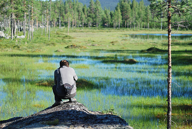 istock Man photographing a swamp in taiga forest. 185270103