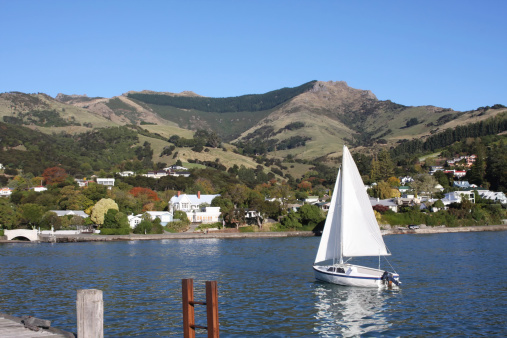 A small sailing boat anchored at a quiet lake.