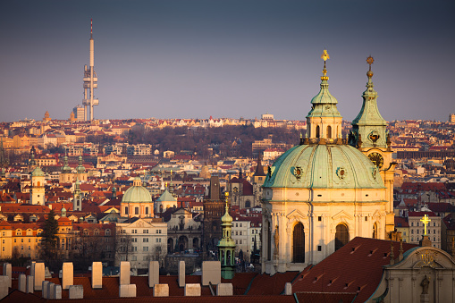 The dome and tower of the St. Nicholas Cathedral with the city of Prague, Czech Republic sprawling off into the distance behind it