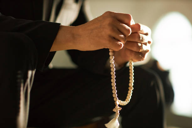 istock Man Holding Rosary in Prayer by Sunlight 1852705150