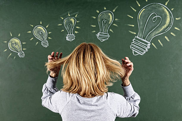 istock Woman Looking Sketched Light Bulbs on Blackboard 185270556