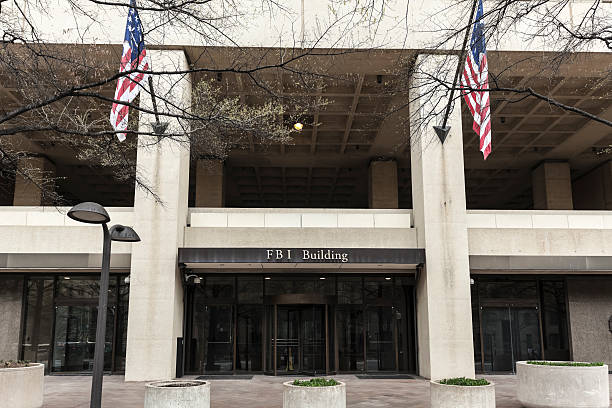 FBI Building Entrance Flanked by Flags Entrance to the FBI Building in Washington, DC. fbi photos stock pictures, royalty-free photos & images