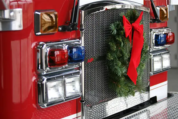 A fire truck with the Christmas wreath on the front.