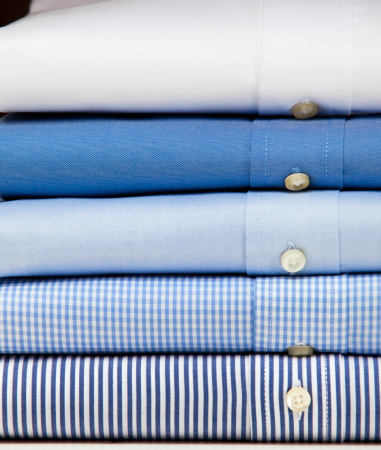 Business shirt button down clothing stacked in a pile