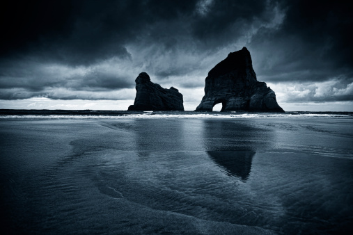 The amazing Wharariki Beach on New Zealand's south island. Toned image with grain added.