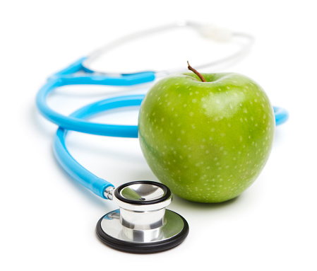 Stethoscope and green apple on white background, Health and nutrition concept.