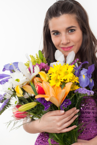 Young woman holding a colorful bunch of natural flowers.