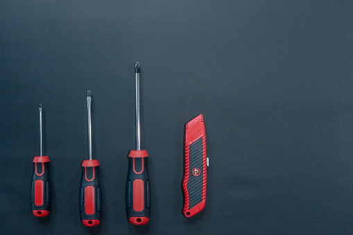 Red and black tools on black background with copy space