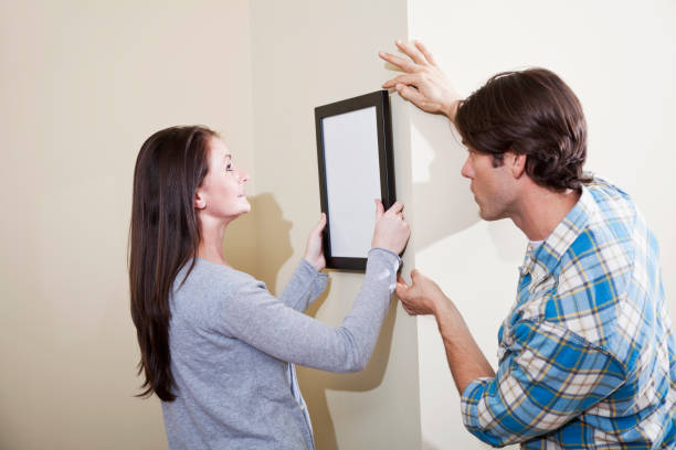 istock Couple hanging picture on wall 185271094