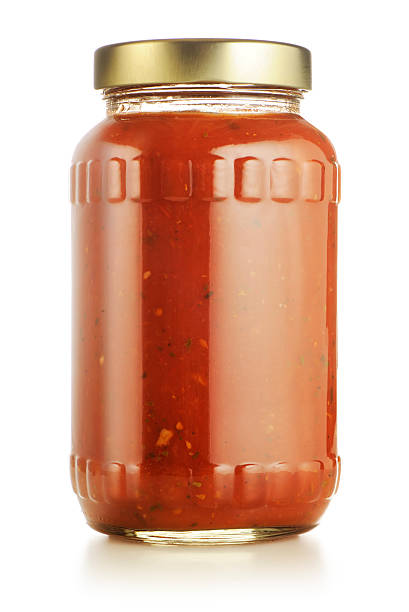 Tomato or marinara sauce Jar of spicy tomato or marinara sauce isolated on white. More tomatoes in lightbox below... marinara stock pictures, royalty-free photos & images